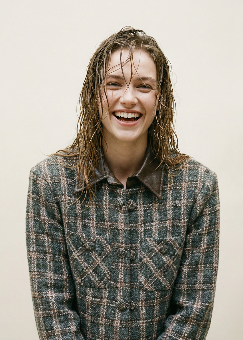 Cropped plaid jacket. The standout feature is its removable leather collar—securely attached with buttons. The jacket’s textured fabric is woven with a subtle, light-reflecting fiber. Metallic hoops, adding a vintage-inspired twist. Double front pockets and covered buttons