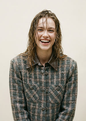 Cropped plaid jacket. The standout feature is its removable leather collar—securely attached with buttons. The jacket’s textured fabric is woven with a subtle, light-reflecting fiber. Metallic hoops, adding a vintage-inspired twist. Double front pockets and covered buttons