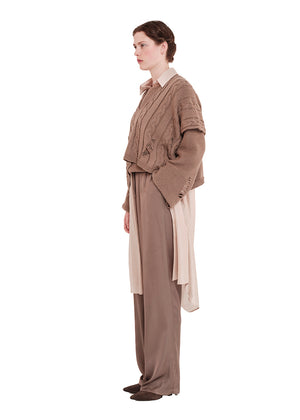 Woman wearing a brown outfit with a matching vest and pants on a white background