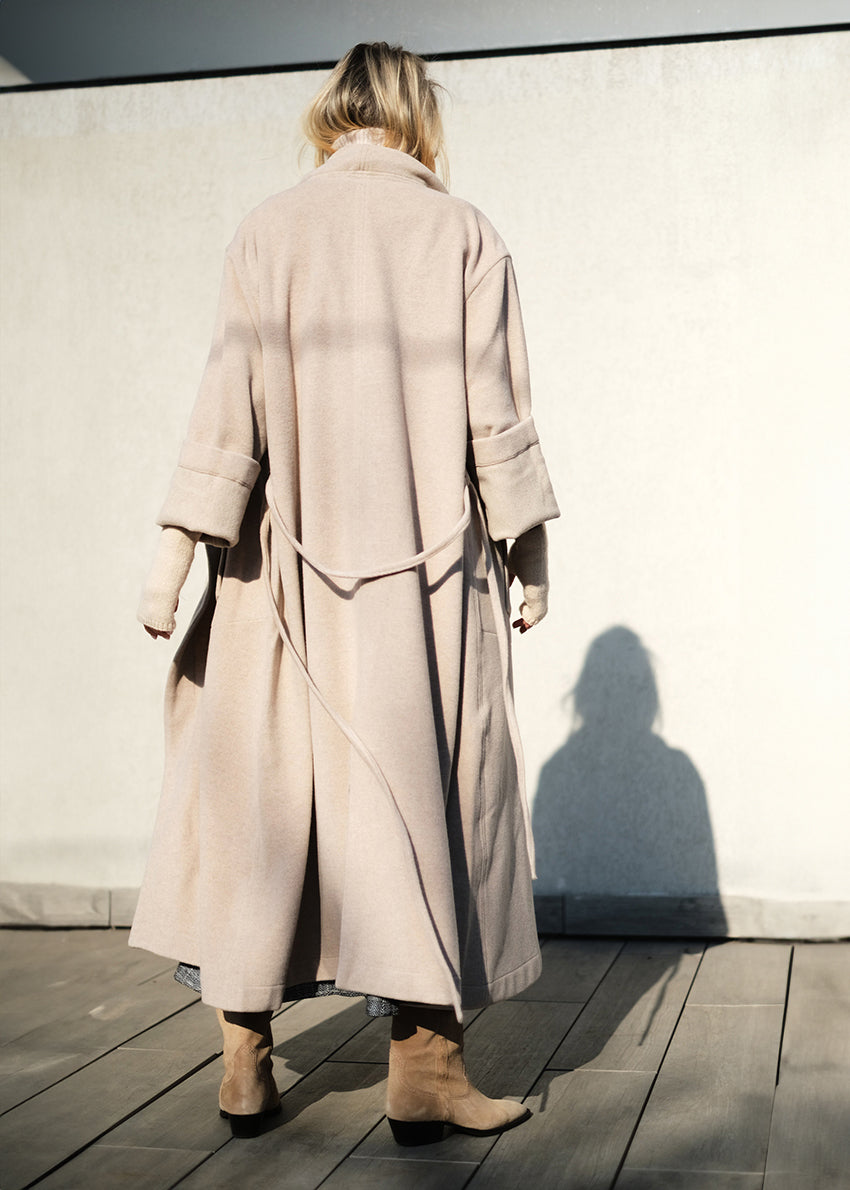 Woman wearing a beige wool coat from back