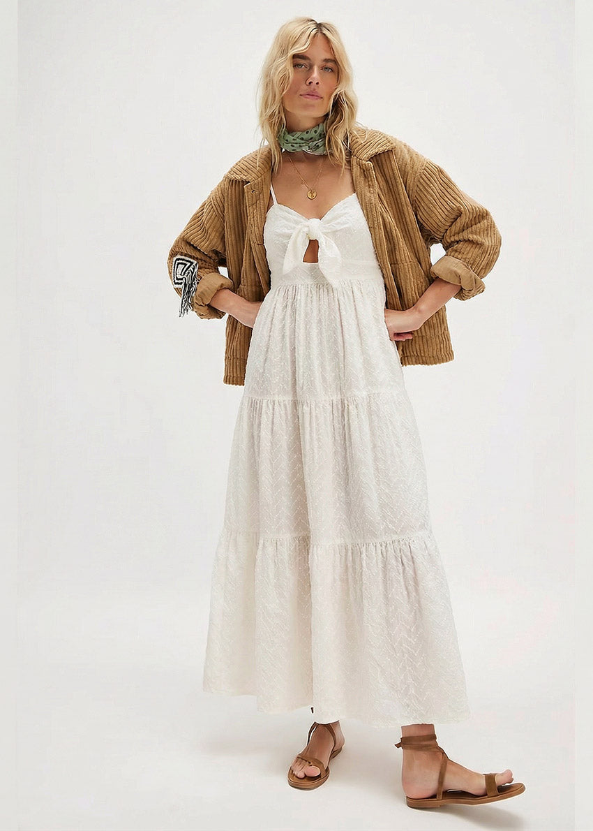 Woman wearing a white dress with a brown jacket on a white background