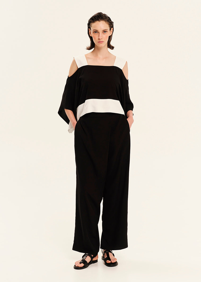 Woman wearing a black and white outfit on a plain background