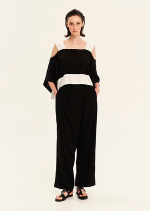 Woman wearing a black and white outfit on a plain background