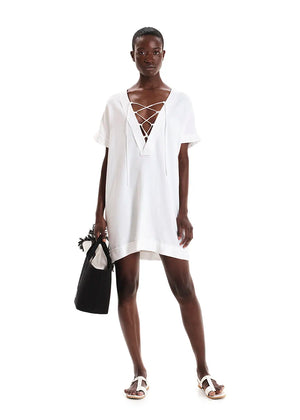 White tunic with front detail made of a linen and bamboo blend with a linen look.It has a boxy shape with short sleeves and mini length. It has a plunging “V” neck with ribbons that tie in “X” shapes while the fringes at the seams highlight its raw look.
