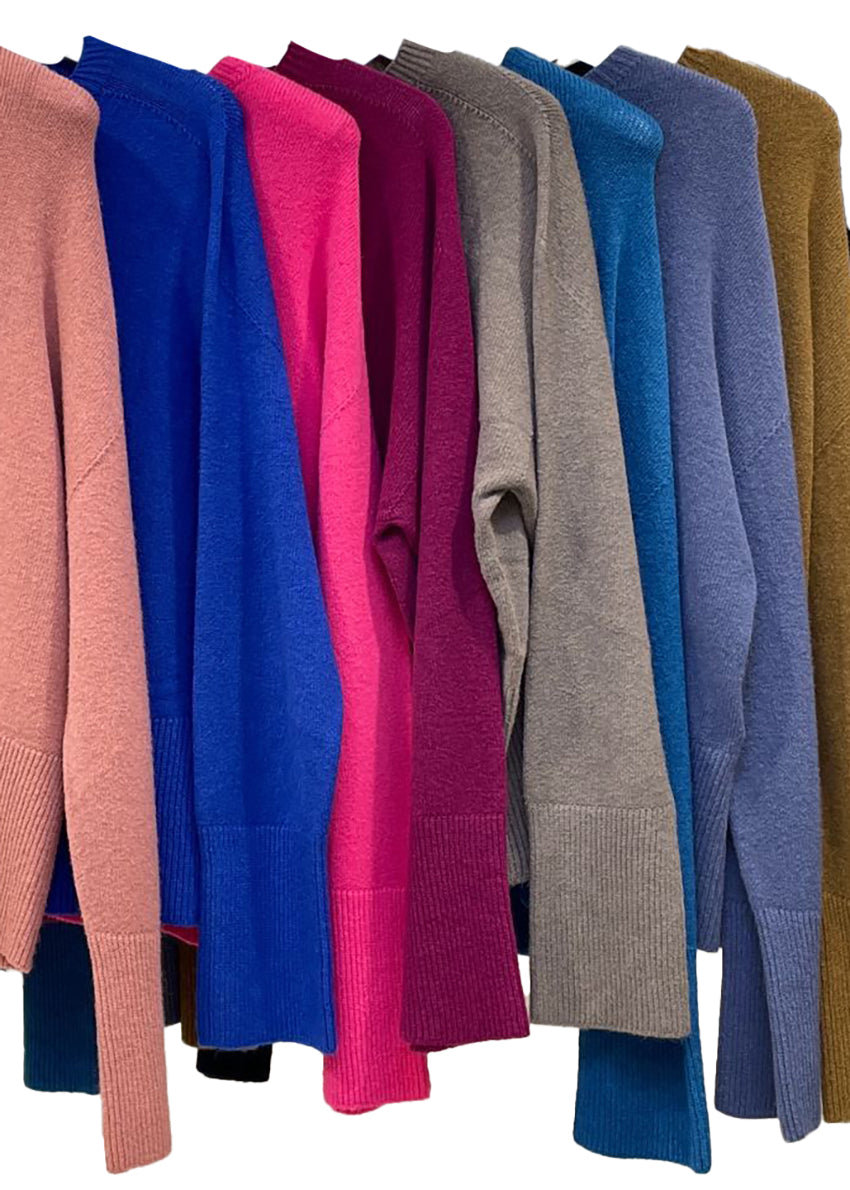Row of colorful sweaters on a white background