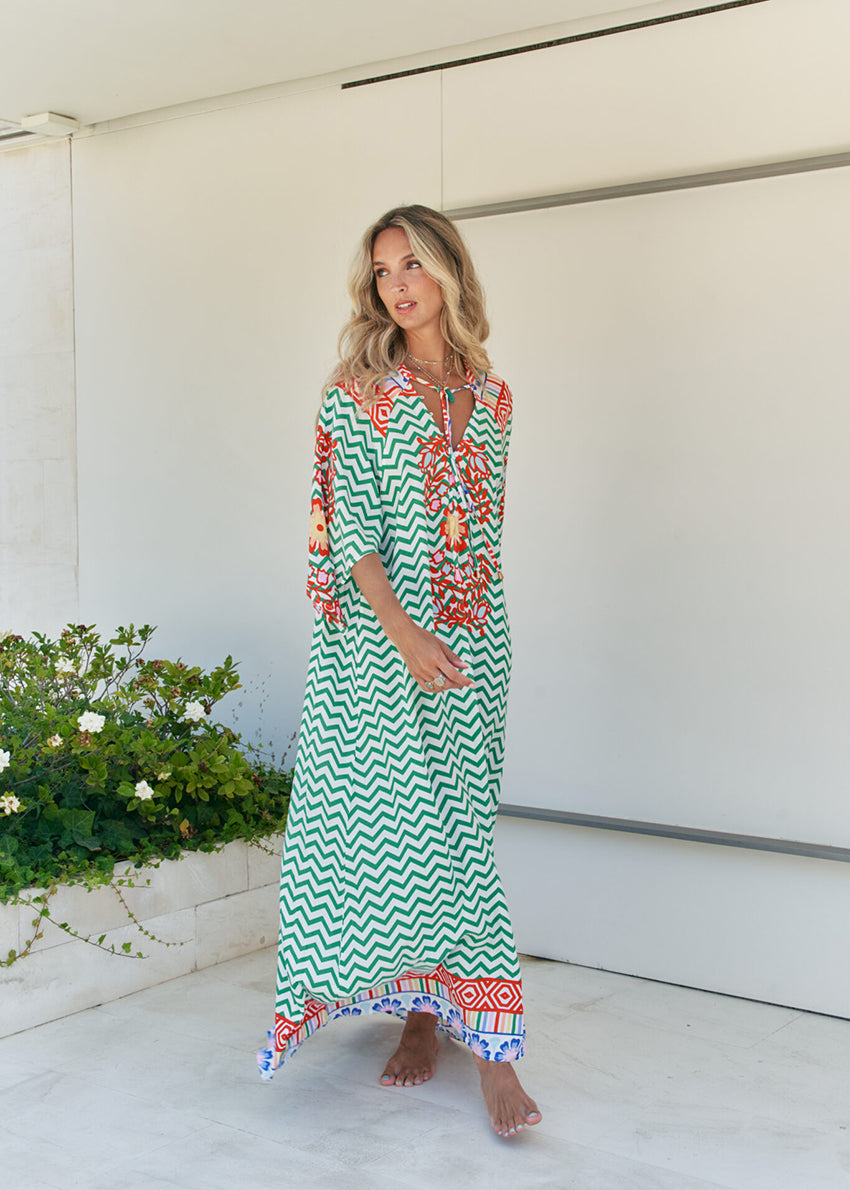 Femme and floral, this forever timeless maxi dress - inspired maxi is featured in a flowy, pintucked back and shoulder silhouette with button-front detailing, tassle and subtle scarf sleeve.