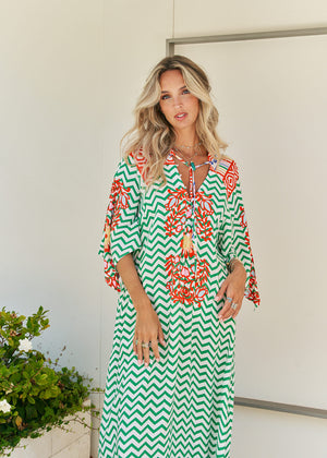 Femme and floral, this forever timeless maxi dress - inspired maxi is featured in a flowy, pintucked back and shoulder silhouette with button-front detailing, tassle and subtle scarf sleeve.