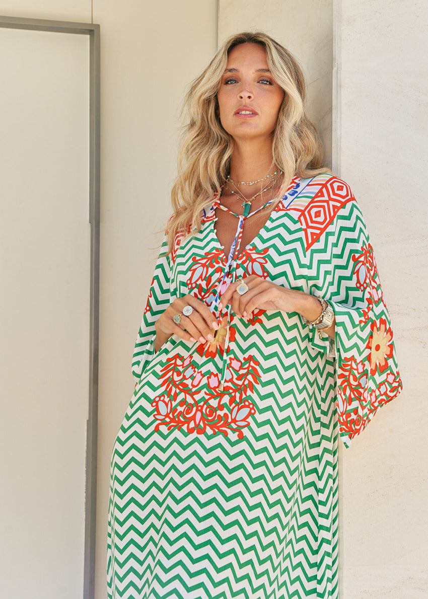 Femme and floral, this forever timeless maxi dress - inspired maxi is featured in a flowy, pintucked back and shoulder silhouette with button-front detailing, tassle and subtle scarf sleeve.