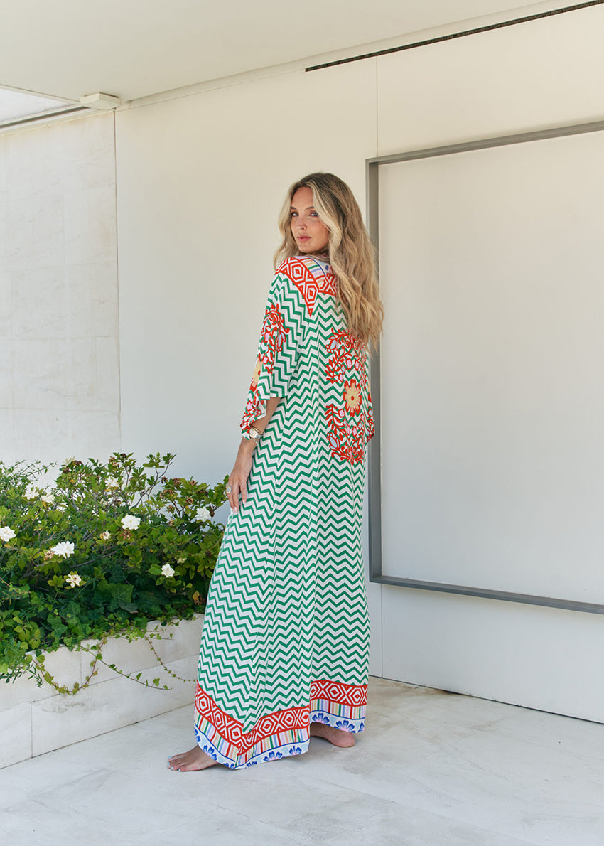 Femme and floral, this forever timeless maxi dress - inspired maxi is featured in a flowy, pintucked back and shoulder silhouette with button-front detailing, tassle and subtle scarf sleeve.
