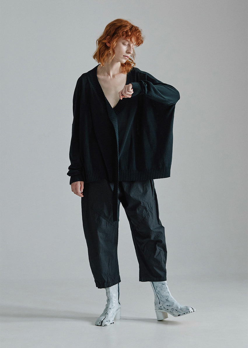 Cropped, drop-crotch unisex trousers, made from cotton poplin, in relaxed cut. These pants have an elastic waistband and diagonal seams just above the knee.