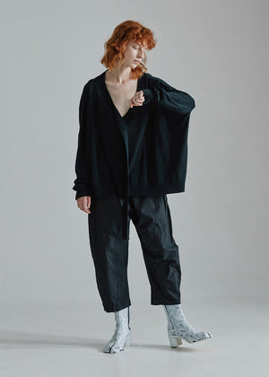 Cropped, drop-crotch unisex trousers, made from cotton poplin, in relaxed cut. These pants have an elastic waistband and diagonal seams just above the knee.