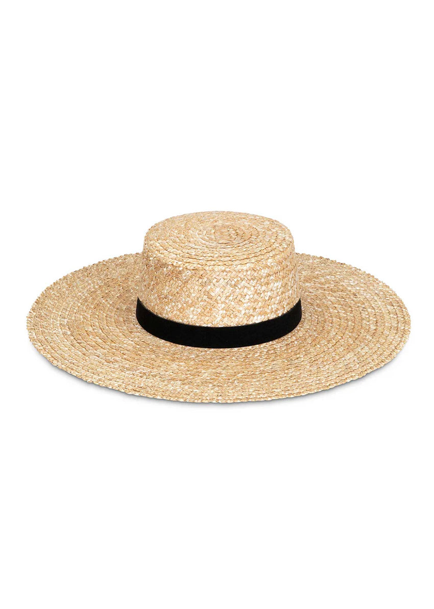 Woman wearing a black swimsuit and straw hat against a gray background