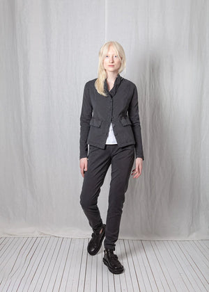 Person wearing a dark gray outfit against a plain background