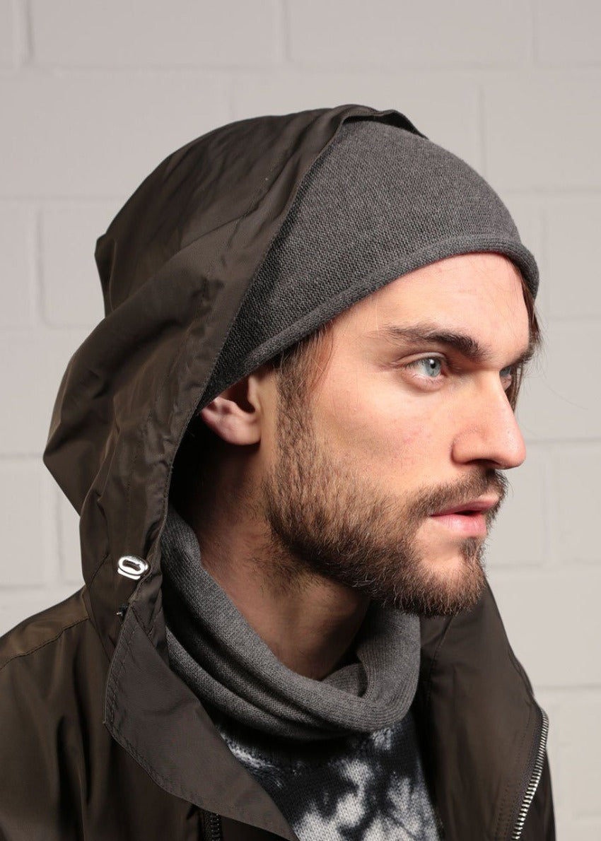 Man wearing a dim grey beanie beret with a black jacket