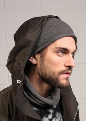 Man wearing a dim grey beanie beret with a black jacket