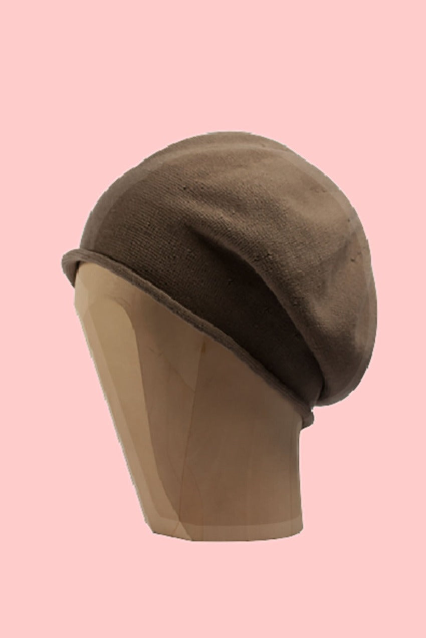 Tan beanie beret on a pink background 