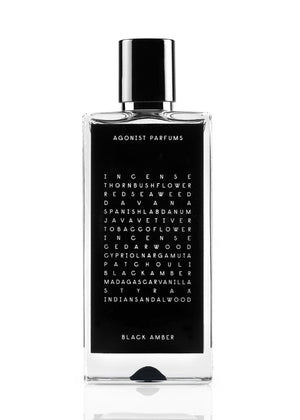 A black glass bottle of Black Amber perfume with a white label featuring text and a black cap.