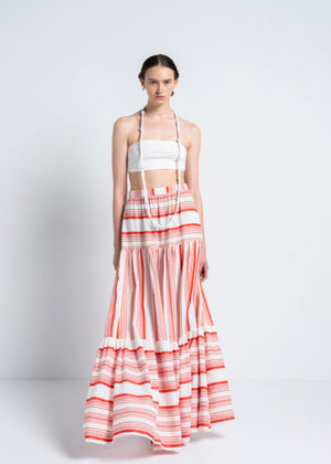 A person wearing a white bustier top with a red skirt 