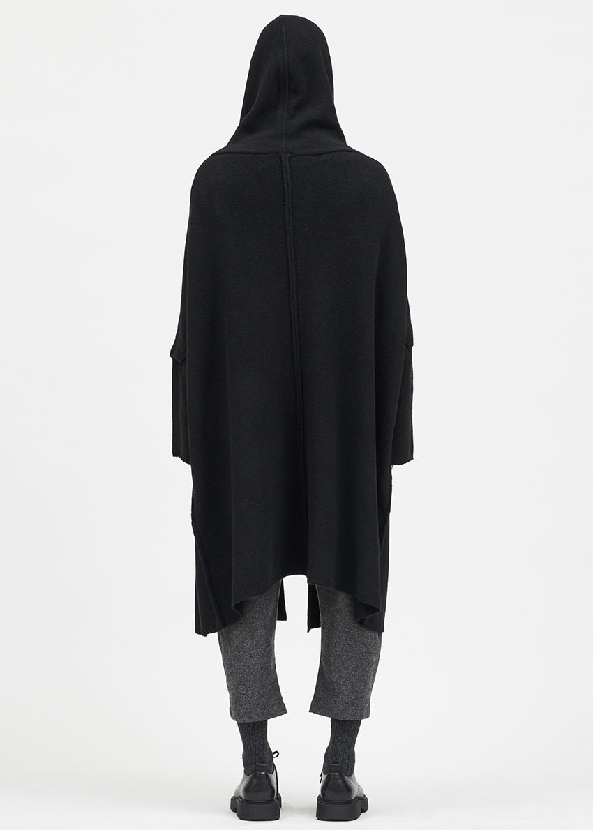 Person wearing a black cardigan on a white background