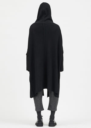 Person wearing a black cardigan on a white background