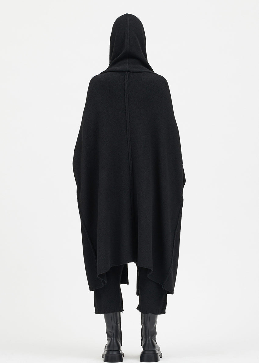 Person wearing a black cardigan on a white background