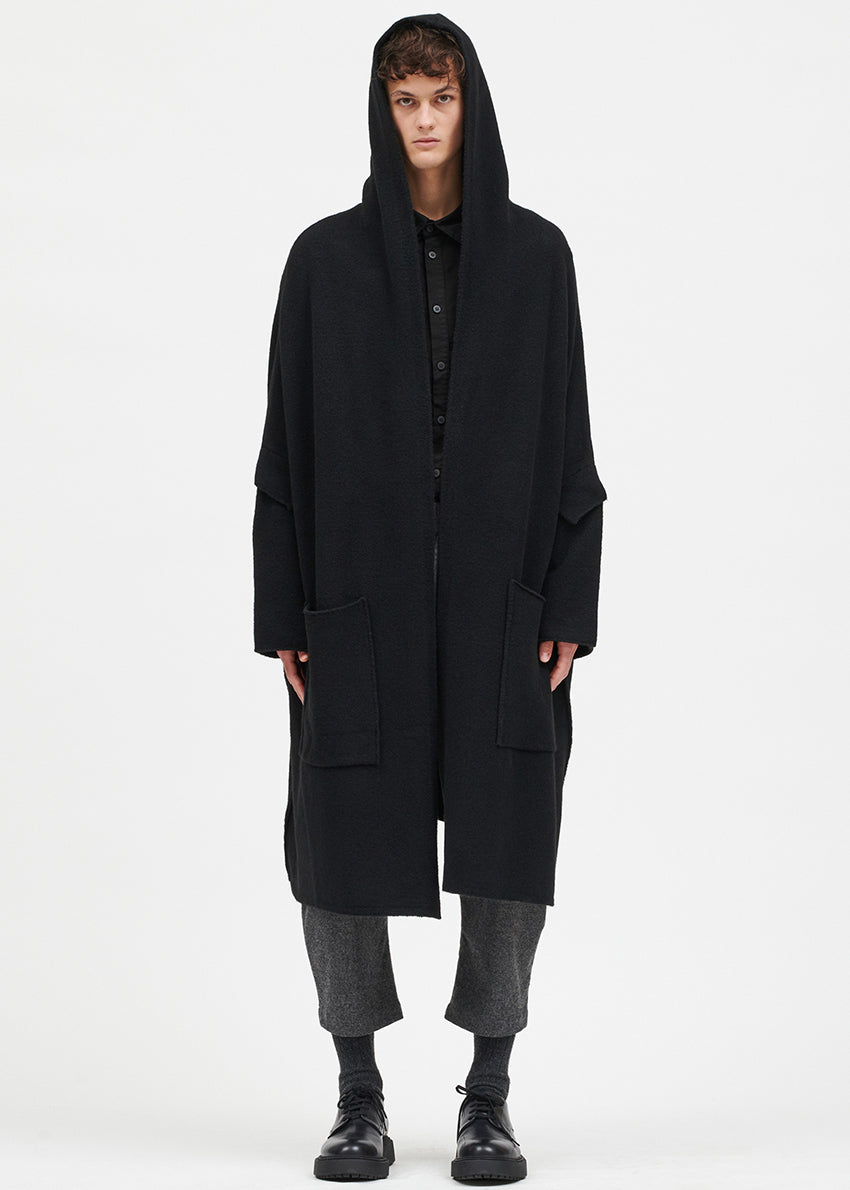 Person wearing a black cardigan on a white background