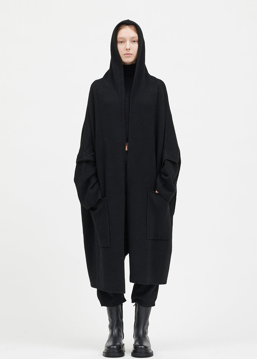 Person wearing a black cardigan on a white background