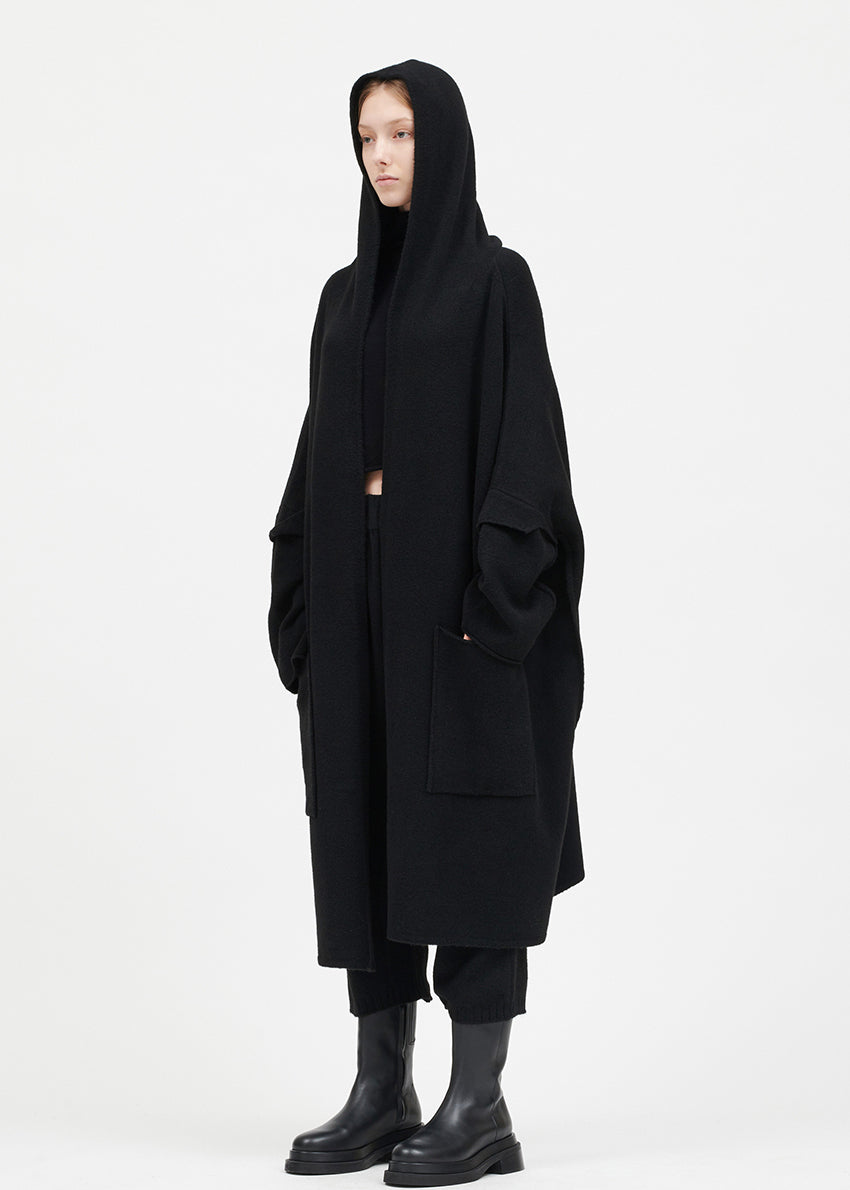 Person wearing a black cardigan on a white background