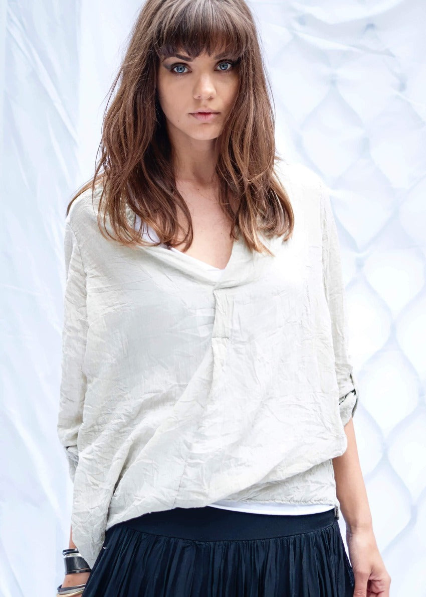 A person wearing a white shirt with black pants on a white background 