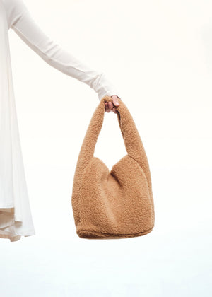 Furry purse made of wool blend fabric. A fashion statement design, it closes with a metallic clasp and it is fully lined.