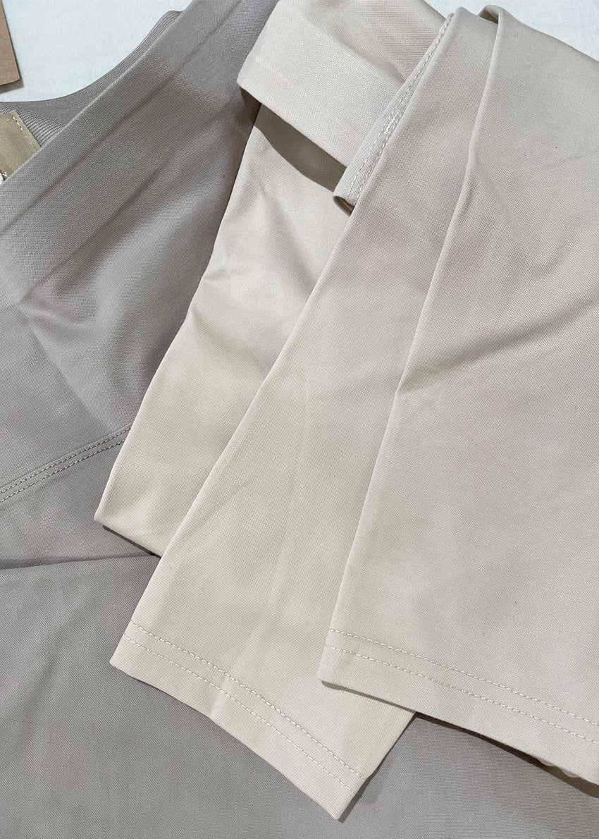 A woman wearing black high-rise cotton leggings and a matching long-sleeve top, paired with over-the-knee black boots.