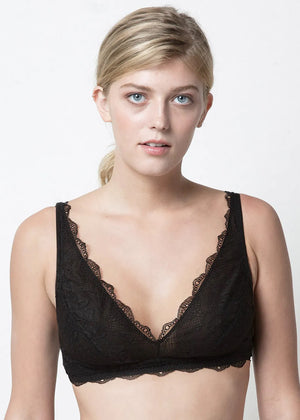 A woman wearing a black lace non-wired and unpadded bra with adjustable straps.