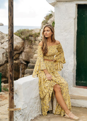 A yellow floral print crop top with asymmetrical sleeves and matching skirt 