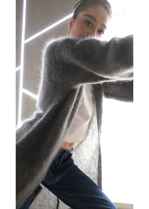 Person wearing a dim grey mohair long cardigan with a white shirt and jeans 