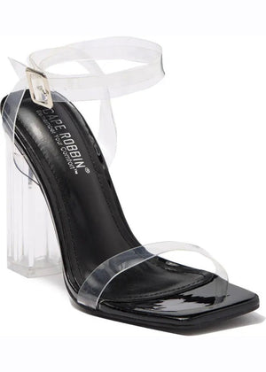 A pair of clear lucite block heels with a chunky heel and a strap design