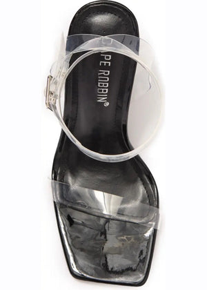 A pair of clear lucite block heels with a chunky heel and a strap design
