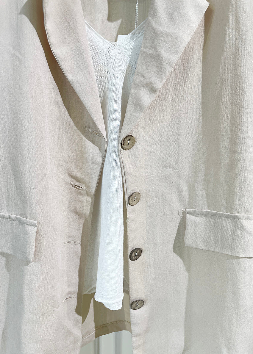 A beige short-sleeve blazer with wood-like detailing on the buttons, displayed against a white background.