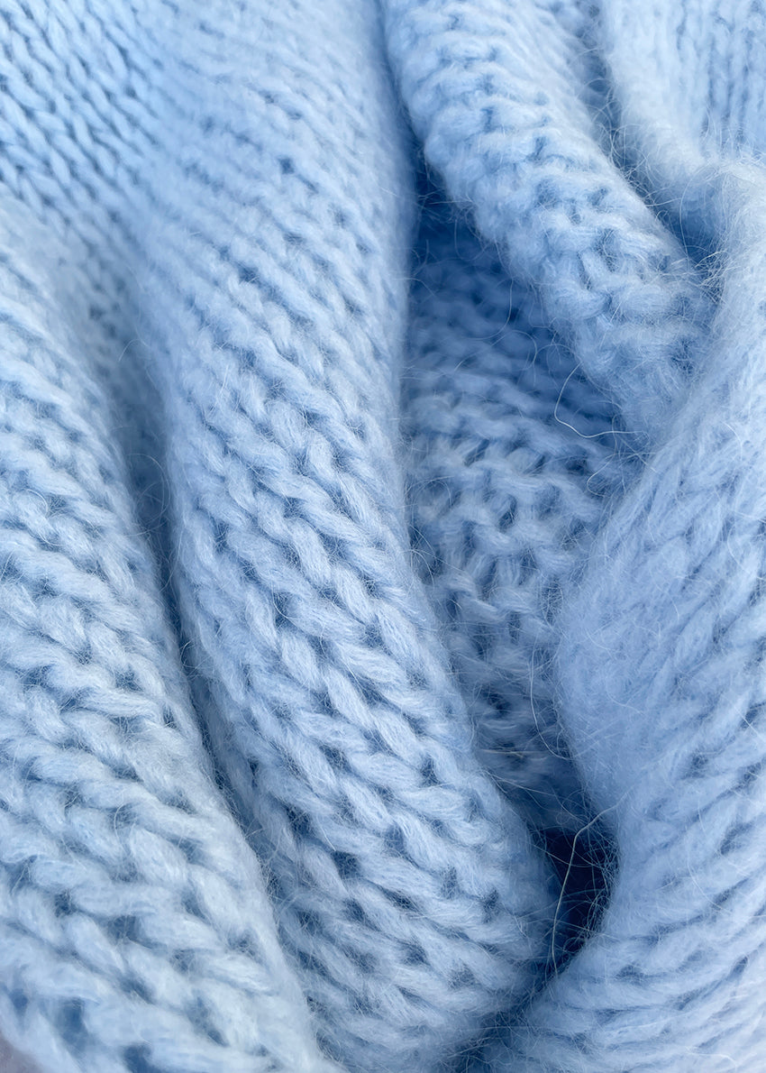 A close up light blue knit cardigan