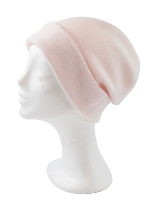 A light pink wool beanie on a white background 