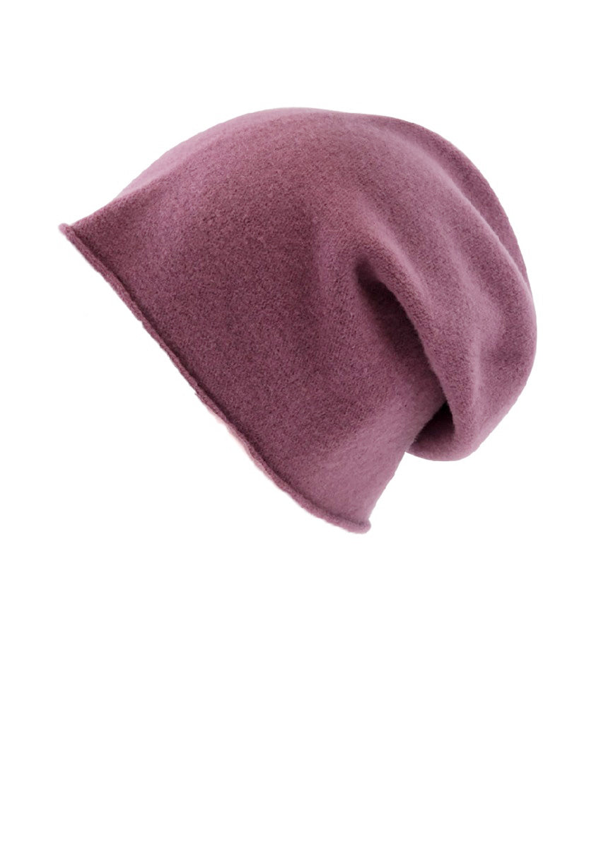 A pale violet red wool beanie on a white background 
