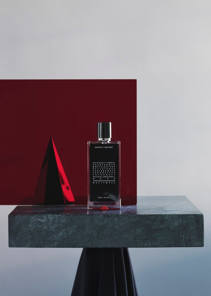 A black bottle of Onyx Pearl perfume with white text listing the fragrance notes: Oriental Flowers, Arabian Oud, White Leather, Heliotrope, Indian Amber, Indonesian Patchouli, Australian Sandalwood, Virginia Cedarwood, White Musk.