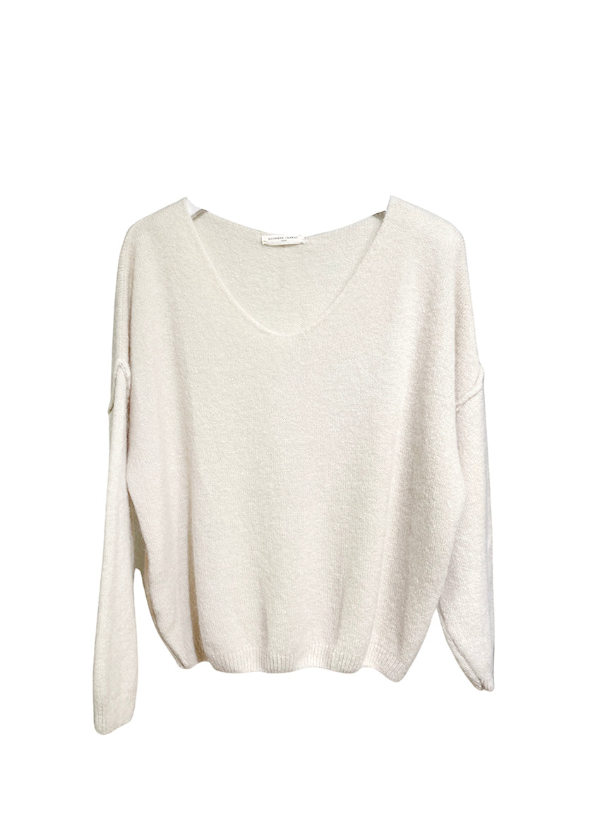 A beige , loose-fitting, long-sleeved sweater with a deep V neckline.