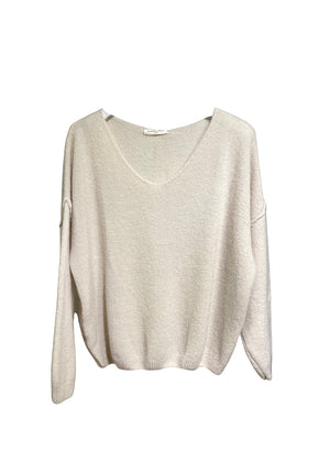 A white, loose-fitting, long-sleeved sweater with a deep V neckline.