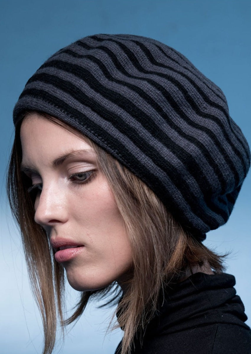 A woman wearing a black and blue striped beanie hat.