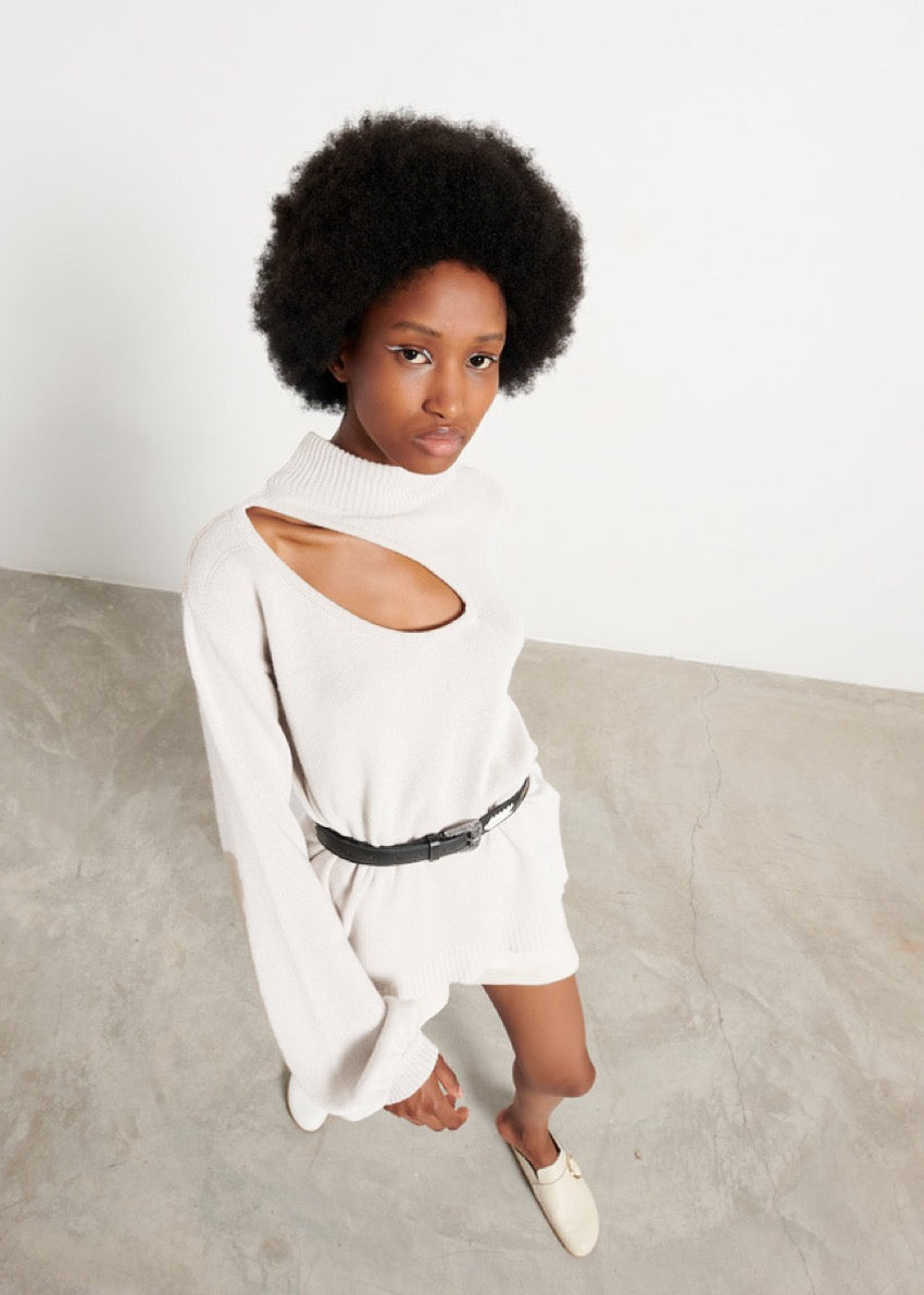 A very soft, classic white sweater, medium length, with a wide slits on the clavicle, shoulder side of the body. Made of merino wool, cashmere and other soft fibres.