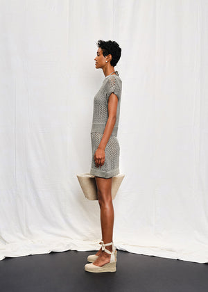 A knit mini dress with a boat neckline and short sleeves, featuring a textured silver shine on the fabric.