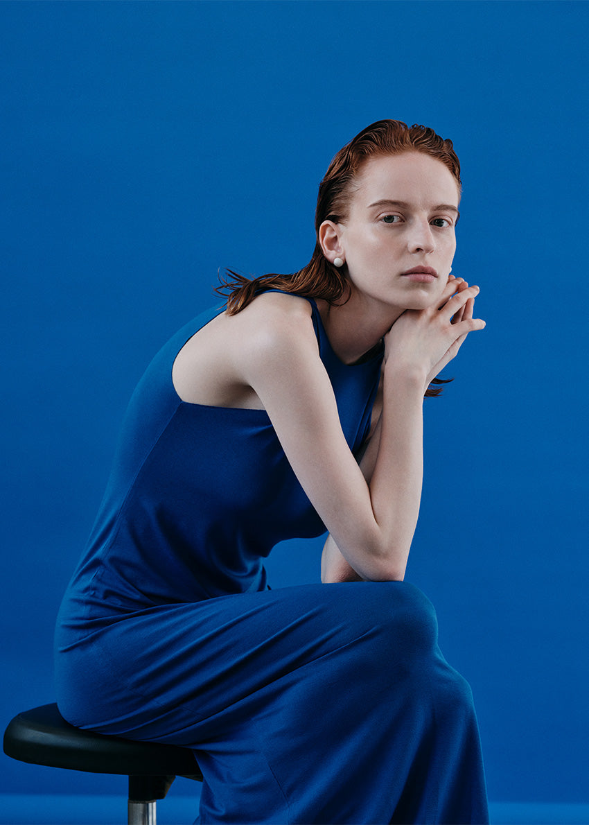 Midi sleeveless midnight blue dress with twisted shoulders made of elastic EcoVero viscose in a fitted silhouette.
It features a round neckline.