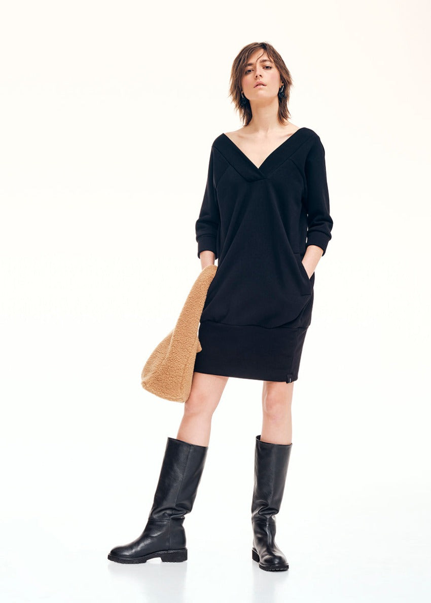 Mini dress made of lightweight neoprene cotton. In an ultra-flattering shape, it has a “V” shaped neckline both at the front and the back, it has ¾ sleeves and side pockets.