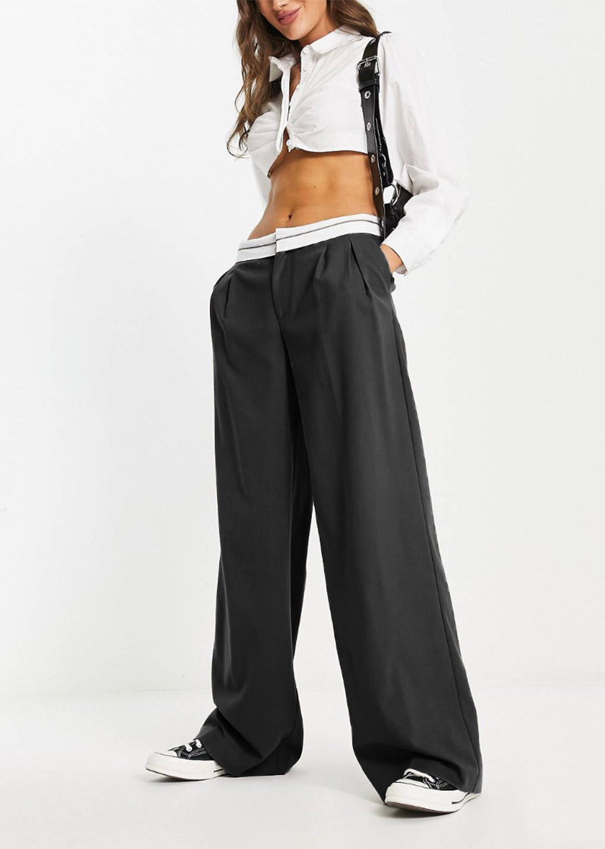Green tailored trousers with a turned down waistband, displayed against a white background.