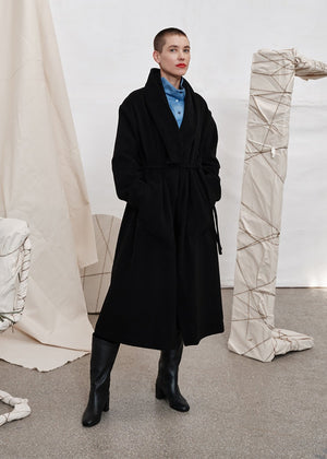 Woman wear a black wool coat with a blue shirt 